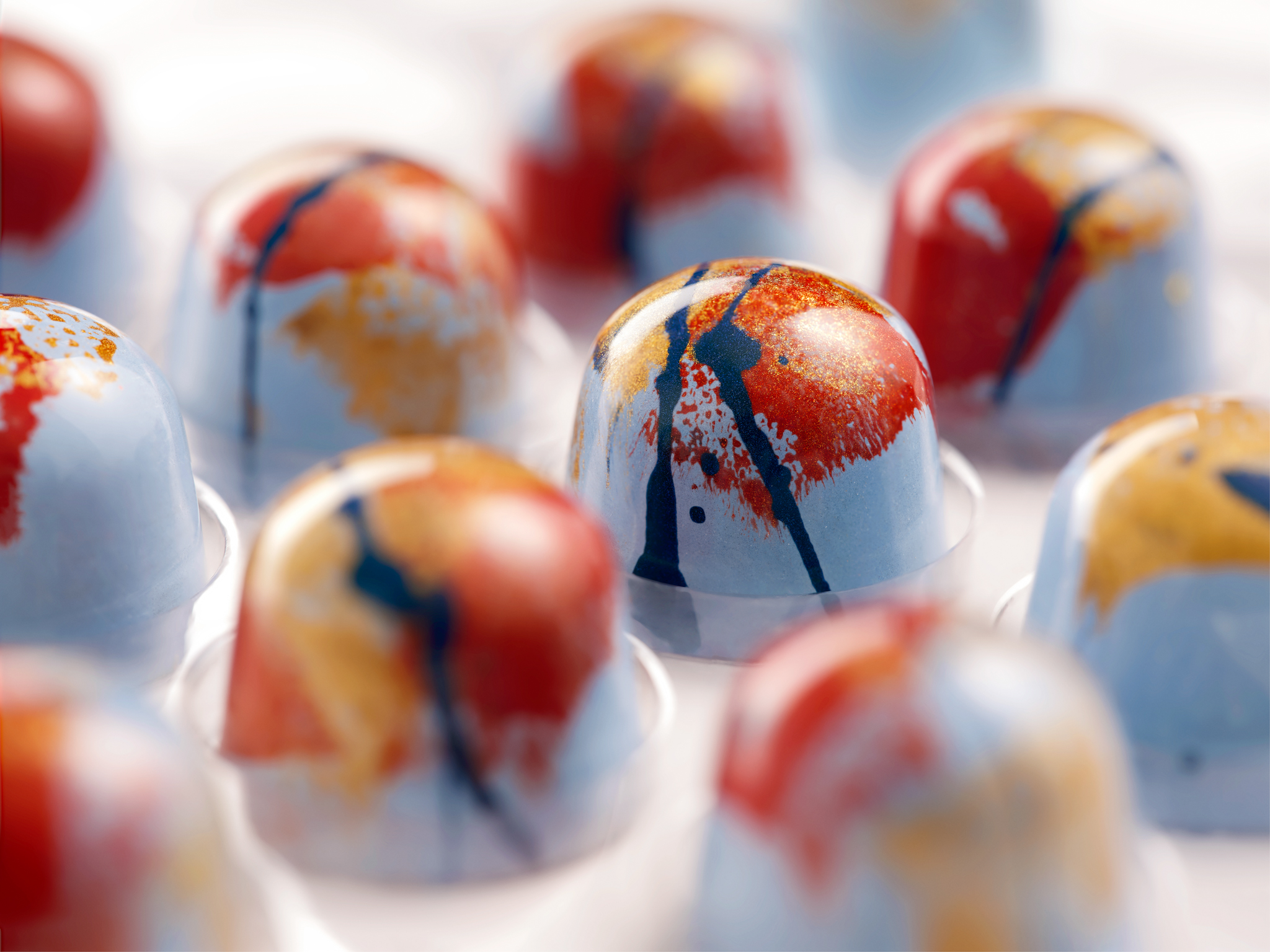 Party tray of colourful hand-painted chocolate bonbons